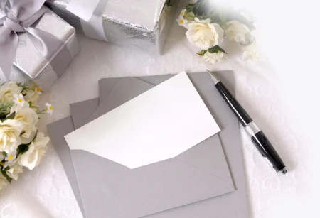 Eleganter Umschlag mit Karte, Geschenkboxen und Blumen für Save the Date Karten zur Hochzeit