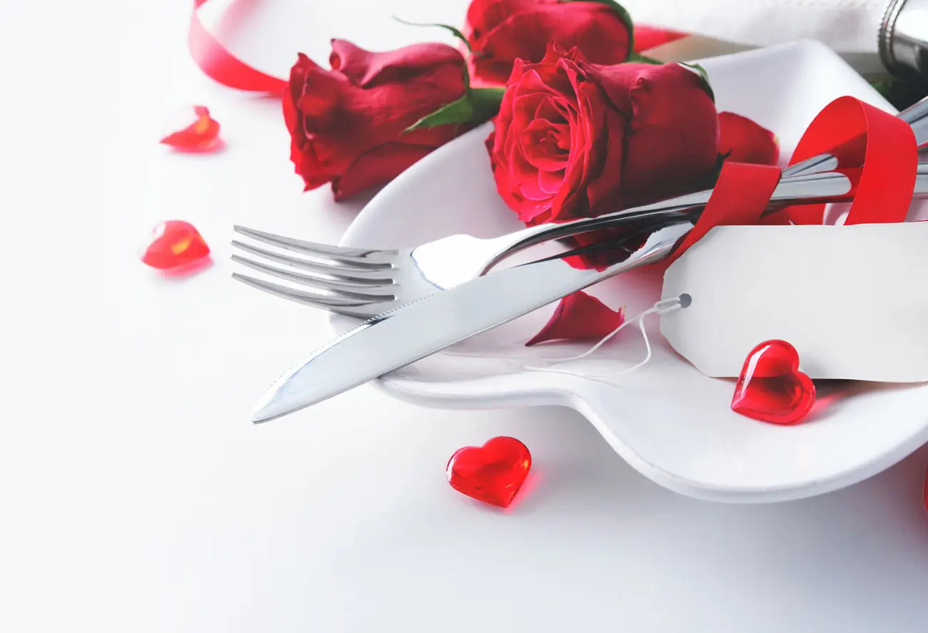 Rote Rosen mit Besteck und Herzdeko als romantische Inspiration für Hochzeitskarten
