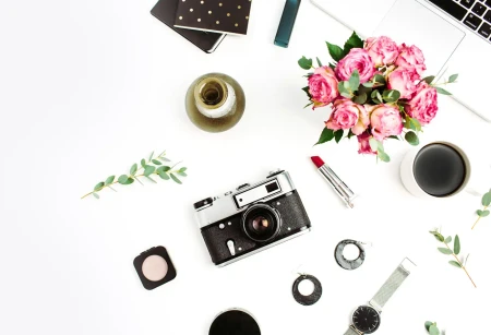 Kamera, rosa Blumen und stilvolle Accessoires auf hellem Hintergrund als moderne Inspiration für Hochzeitseinladungen zum Selbstgestalten